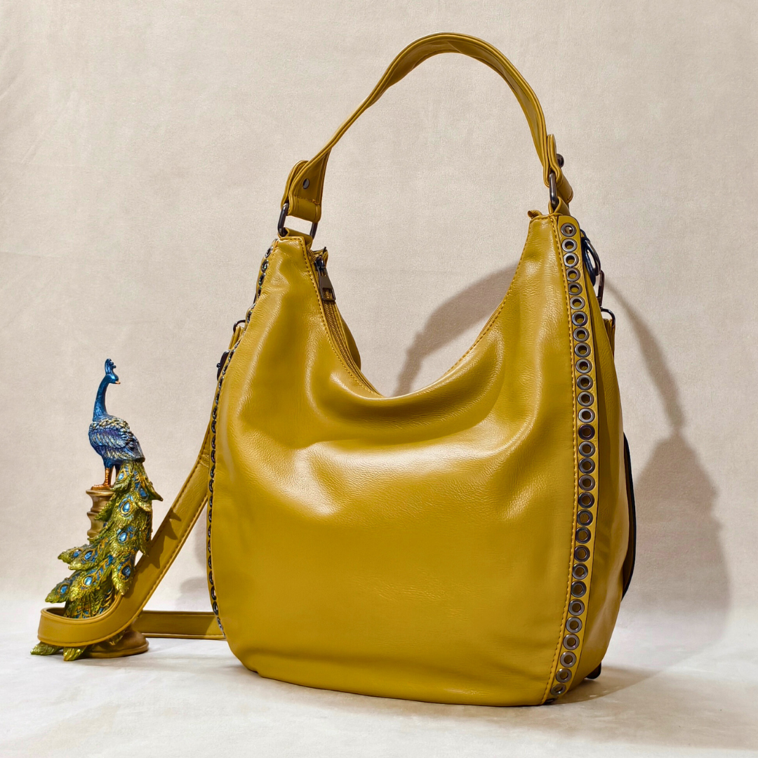 A shoulder bag alongside a peacock decoration