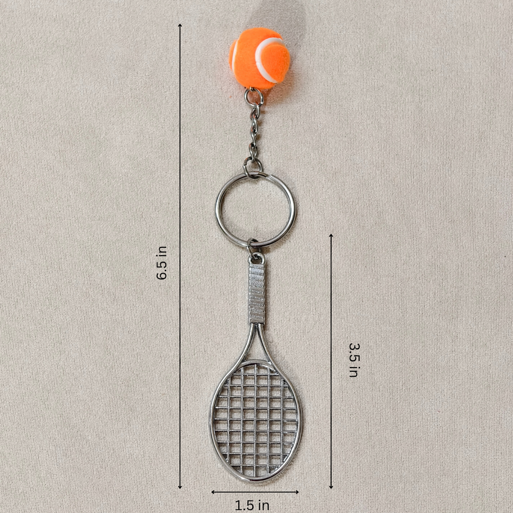 A tennis-themed keychain featuring a silver metal tennis racket and key ring, attached to an orange tennis ball charm, shown on a textured beige background with dimension lines and text indicating measurements.