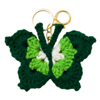 Green butterfly-shaped keychain with gold ring on a white background