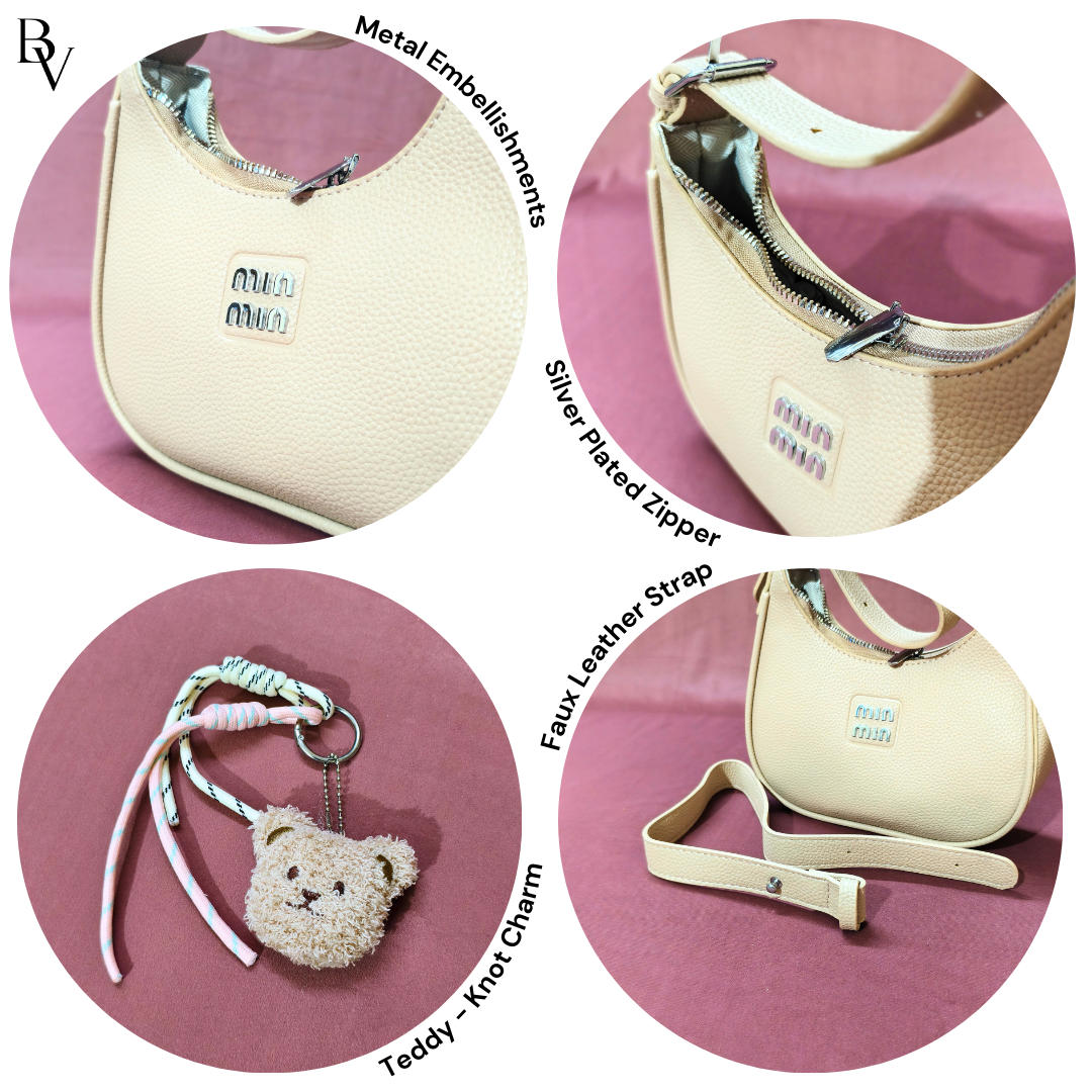 Beige handbag with metal embellishments, silver plated zipper, faux leather strap, and teddy bear keychain on a pink background.