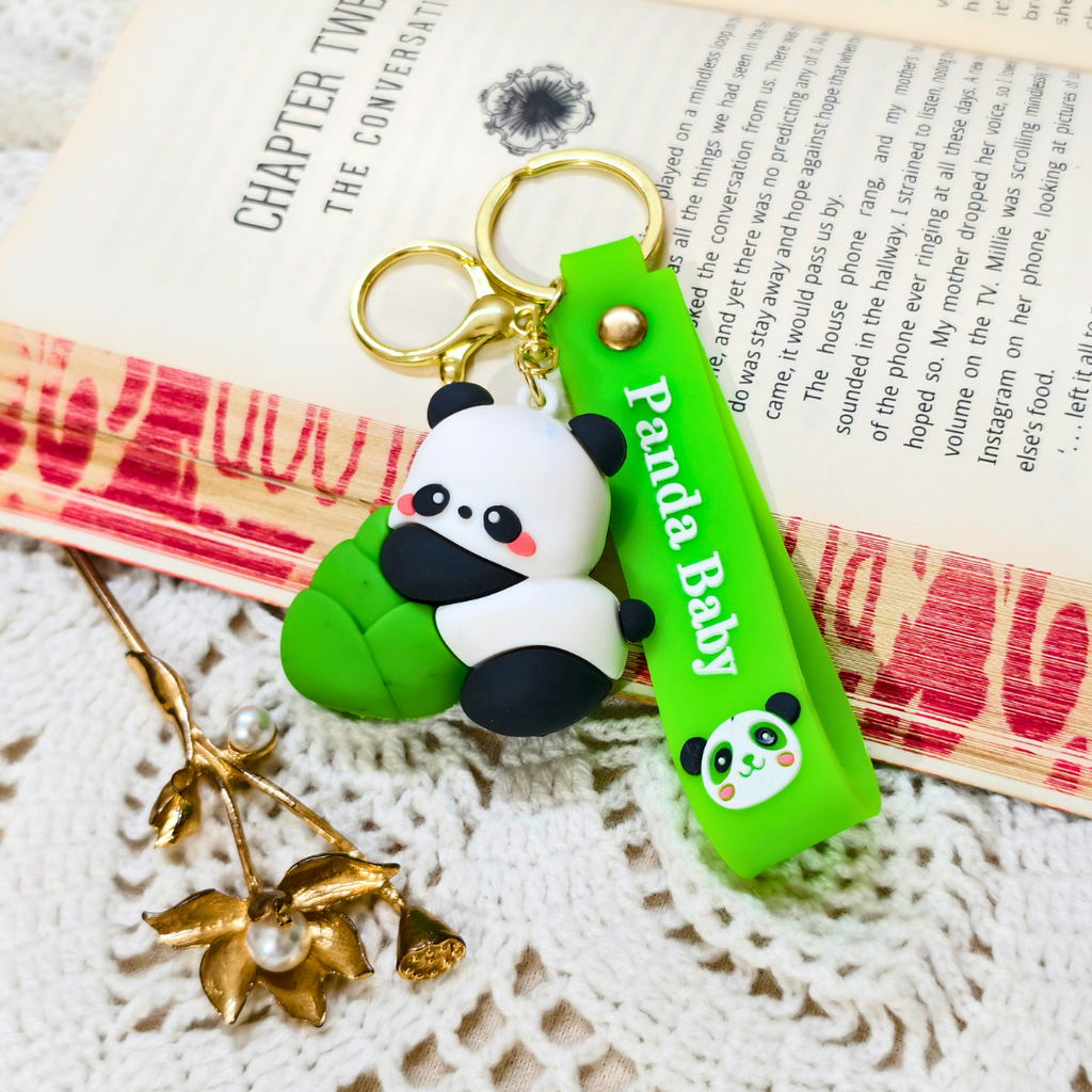 Panda keychain with a green tag on a textured surface