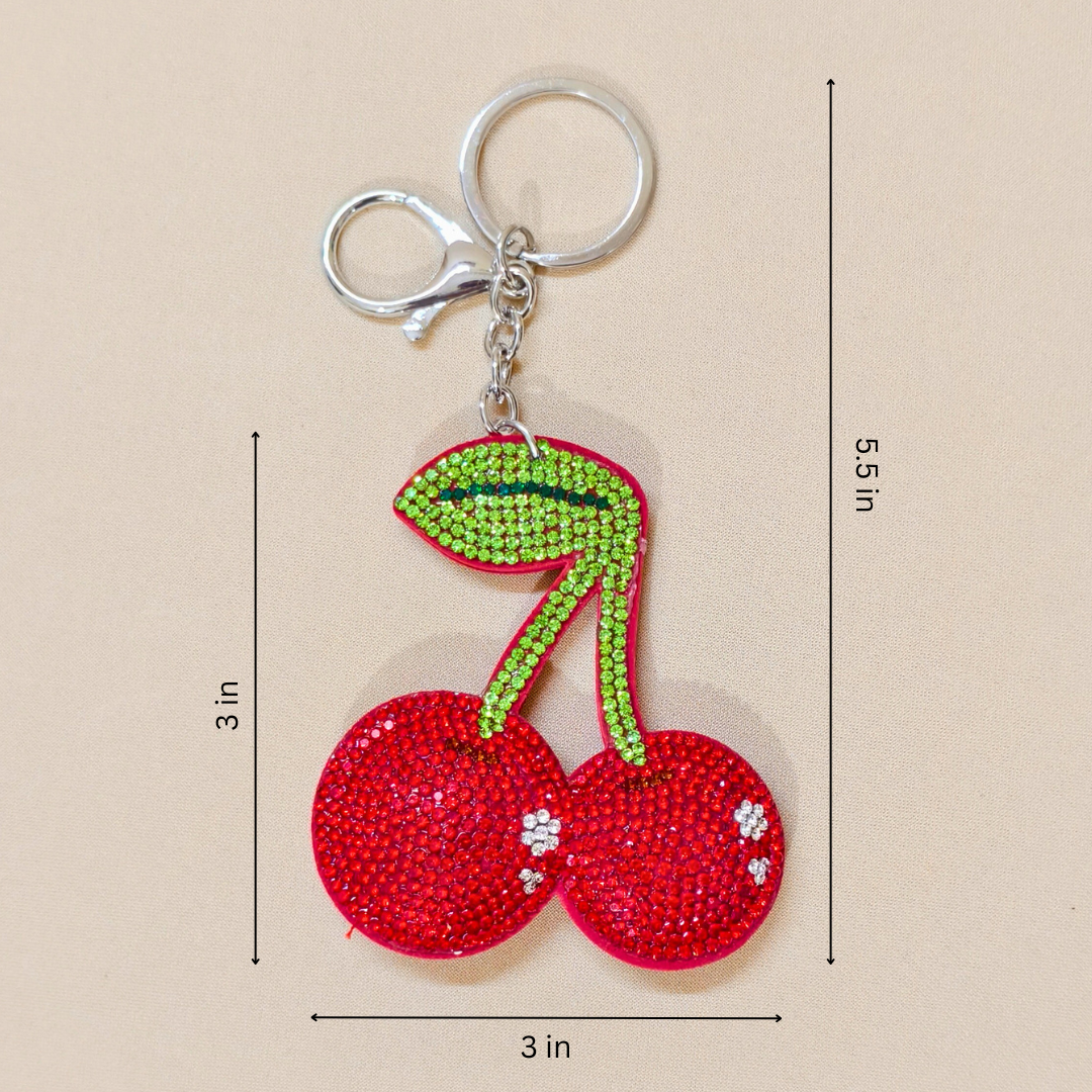 Red Shiny Cherry keychain with a metal latch placed in front of a beige background
