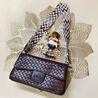 Brown textured handbag with a decorative strap on a textured beige surface