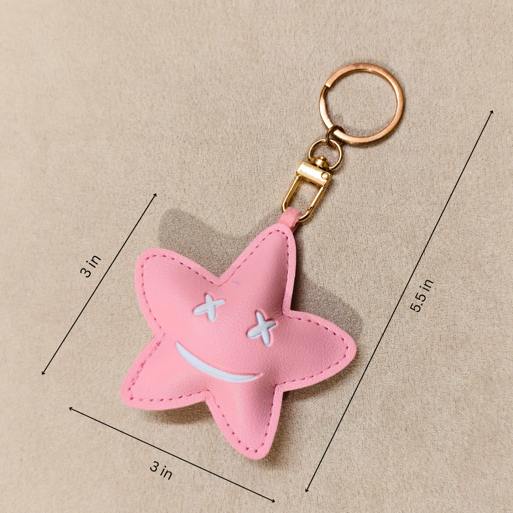 Pink star-shaped keychain with measurements on a beige background