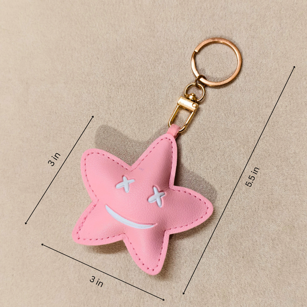 Pink star-shaped keychain with measurements on a beige background