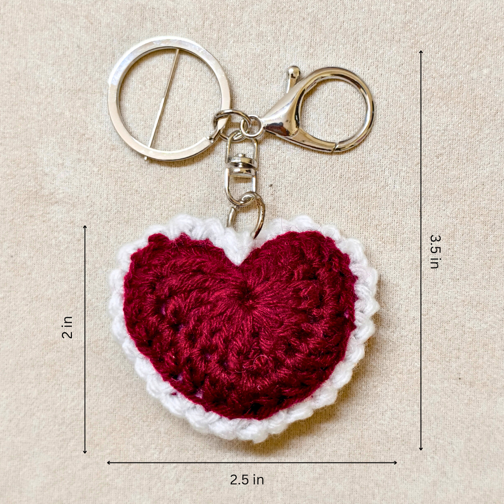 Crocheted heart keychain with measurements on a beige background