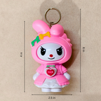 Pink cartoon character keychain with measurements on a beige background