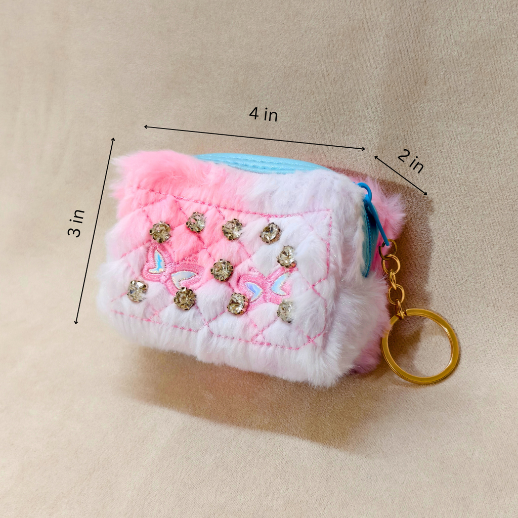 Fluffy pink and white keychain with rhinestones and measurements on a beige background