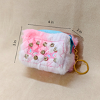 Fluffy pink and white keychain with rhinestones and measurements on a beige background