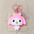 Pink cartoon character keychain with measurements on a beige background