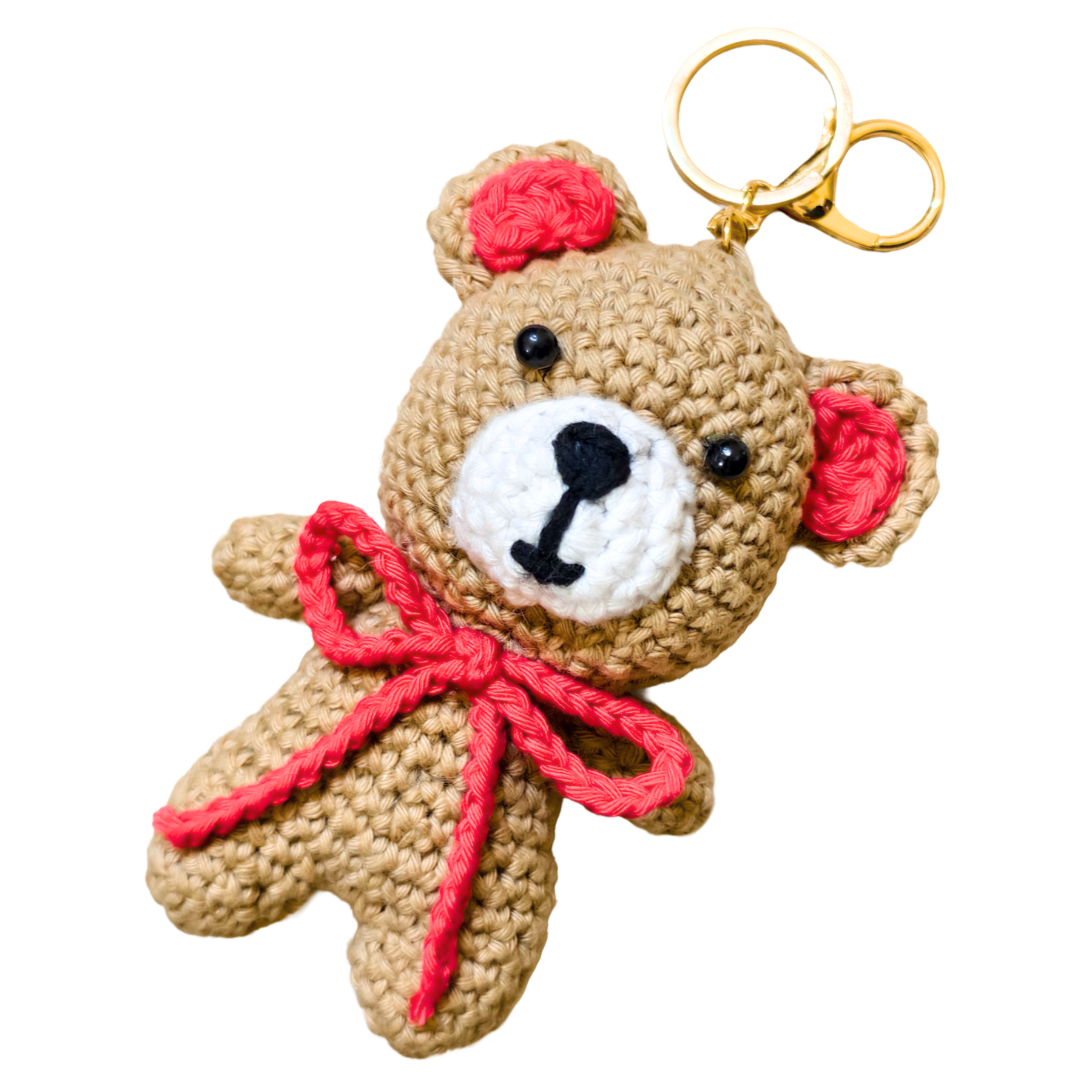 Crocheted teddy bear keychain with a red bow and pink ears on a white background