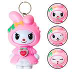 Pink cartoon character keychain with different facial expressions on a white background