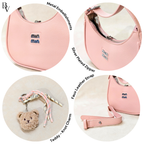 Pink pouch with metal embellishments, silver zipper, faux leather strap, and teddy bear keychain on a white background.