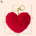 Red heart-shaped fluffy keychain with gold clasp on a beige background, showing measurements.
