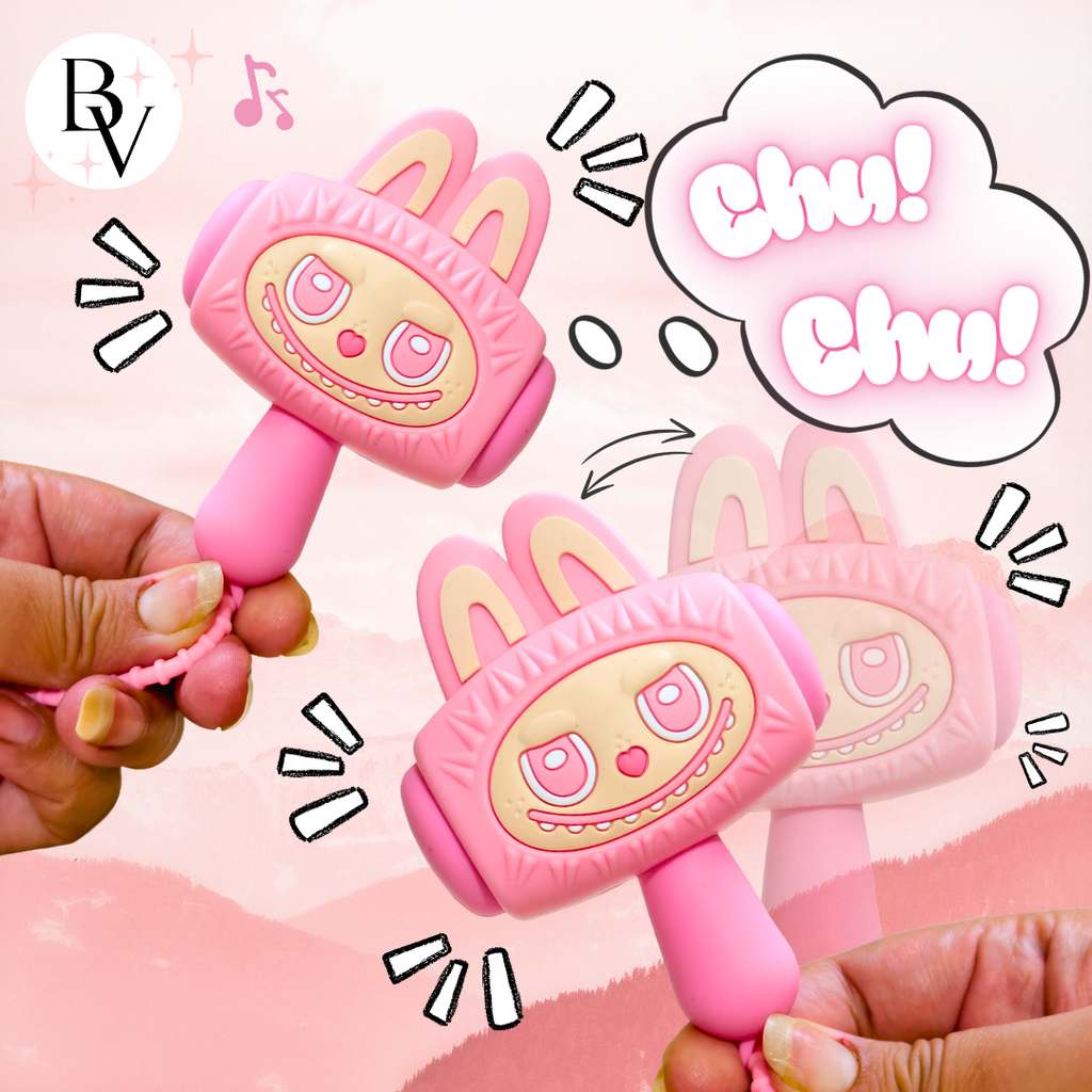 A pink toy phone shaped like a cartoon bunny face, with bunny ears on top, a smiling face graphic, and a coiled cord, Showing features of the product