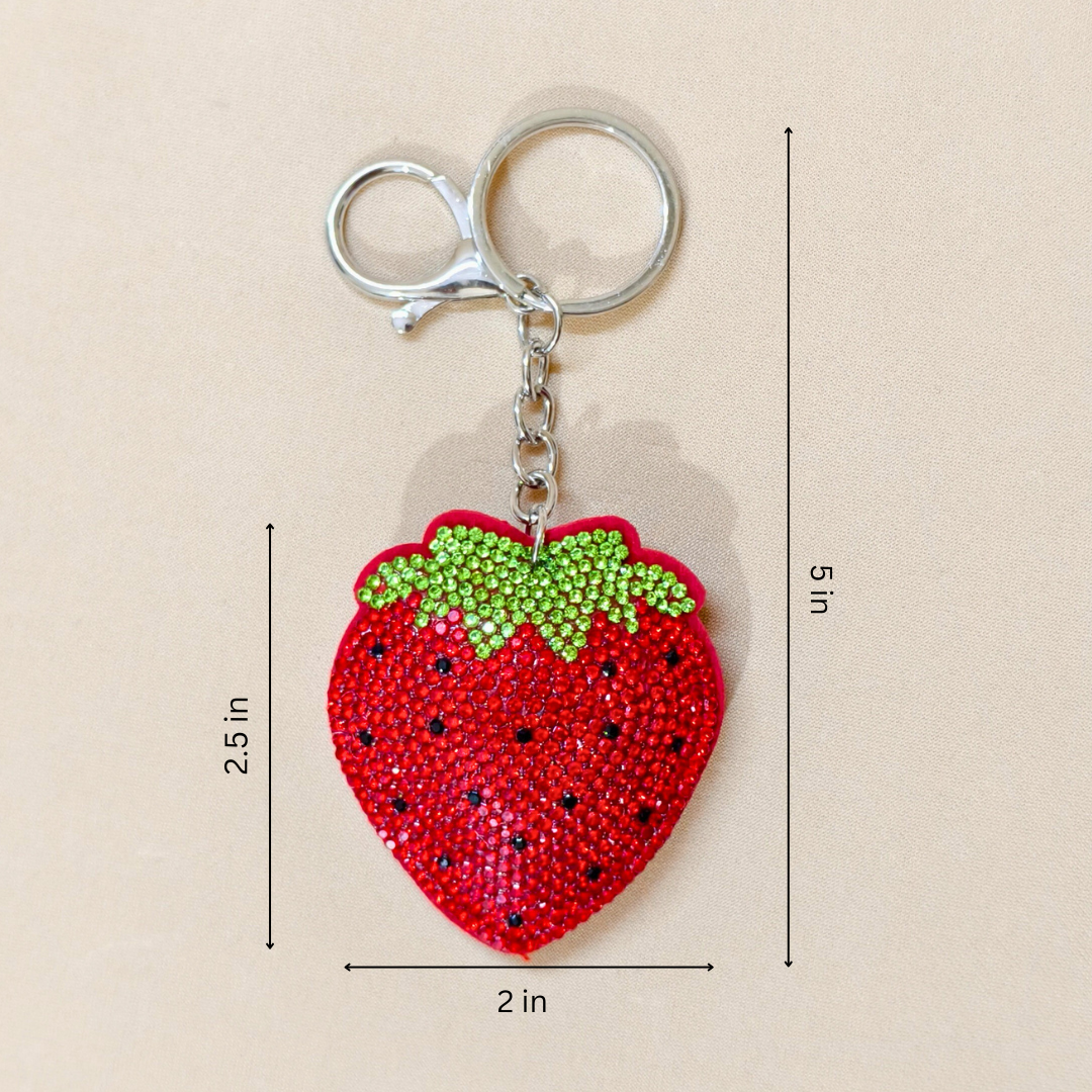red strawberry keychain with metal latch with measurements in front of a beige background