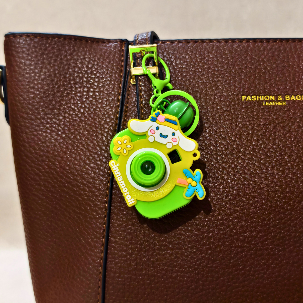 Colorful camera-shaped keychain on a brown leather bag