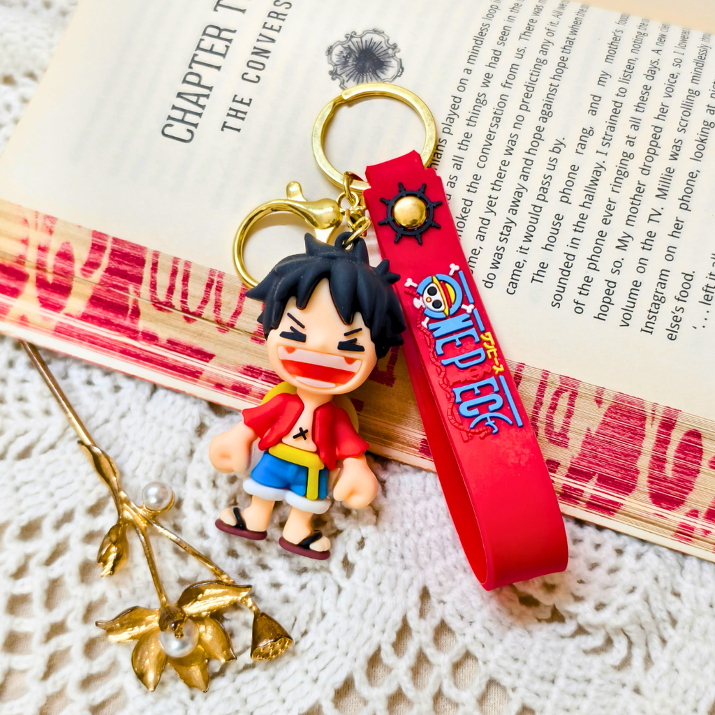 Keychain with character figure and red strap on a textured surface