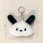 Plush keychain with bunny ears and measurements on a beige background