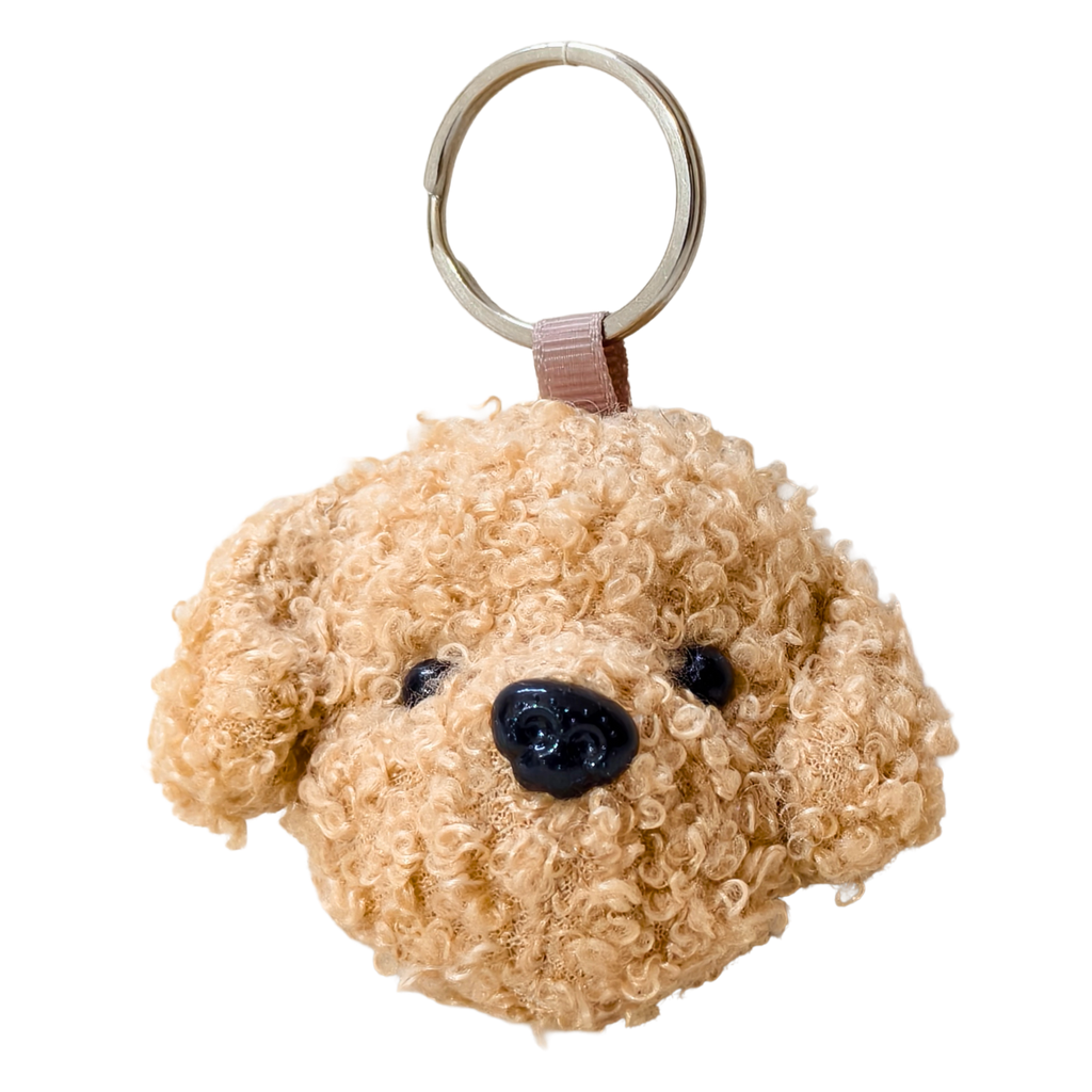 Beige dog-shaped keychain on a white background