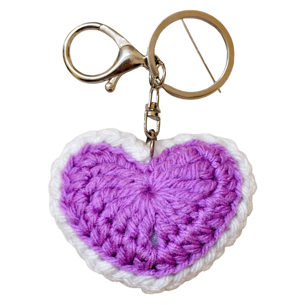 Crocheted heart-shaped keychain with a purple center and white border on a white background