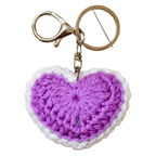 Crocheted heart-shaped keychain with a purple center and white border on a white background