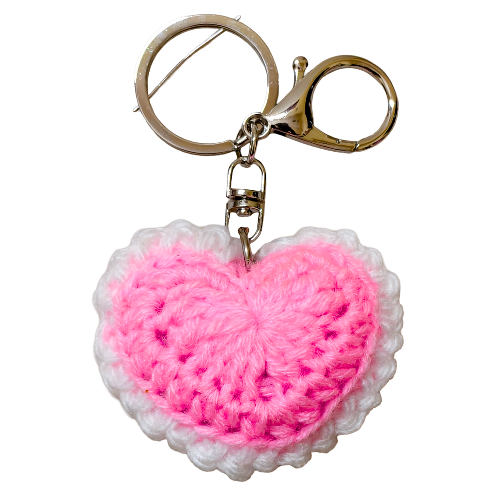 Pink heart-shaped keychain with a gold scissors charm on a white background