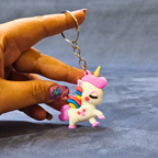 Unicorn keychain held by a hand with a gray background