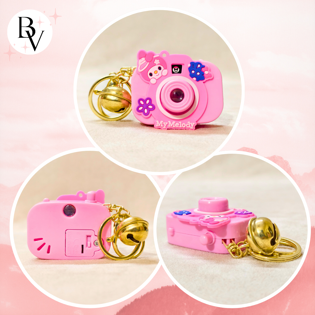 Pink toy camera keychain with gold chain on a pink background