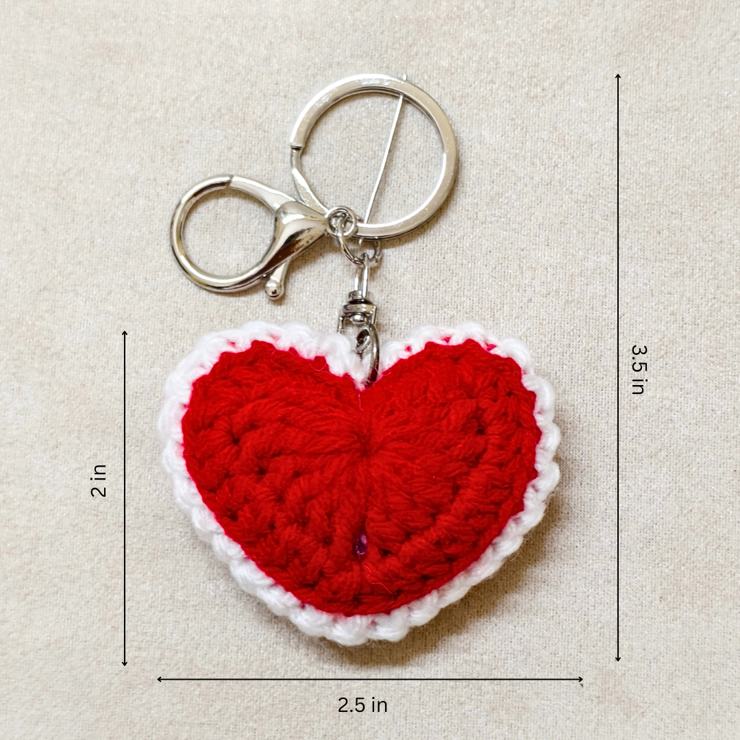 Red heart-shaped keychain with dimensions on a beige background