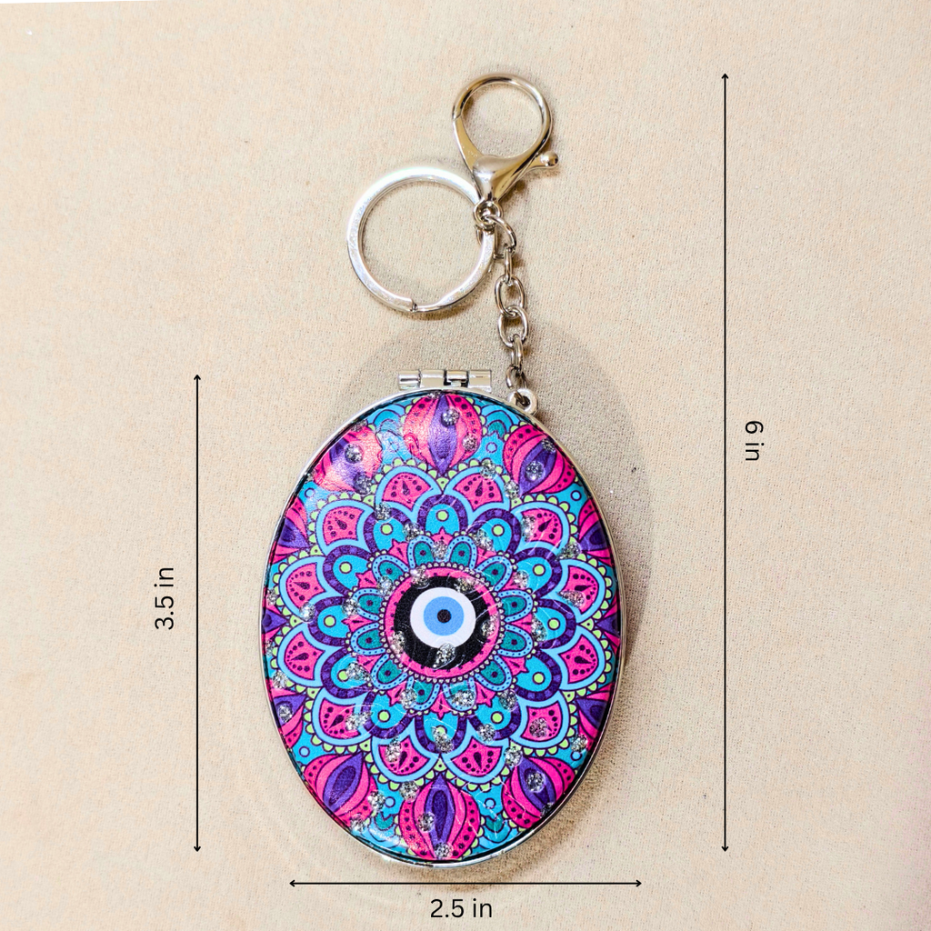 Oval keychain holder with a colorful mandala pattern and evil eye design, shown with dimension lines indicating 3.5 in height, 6 in overall height, and 2.