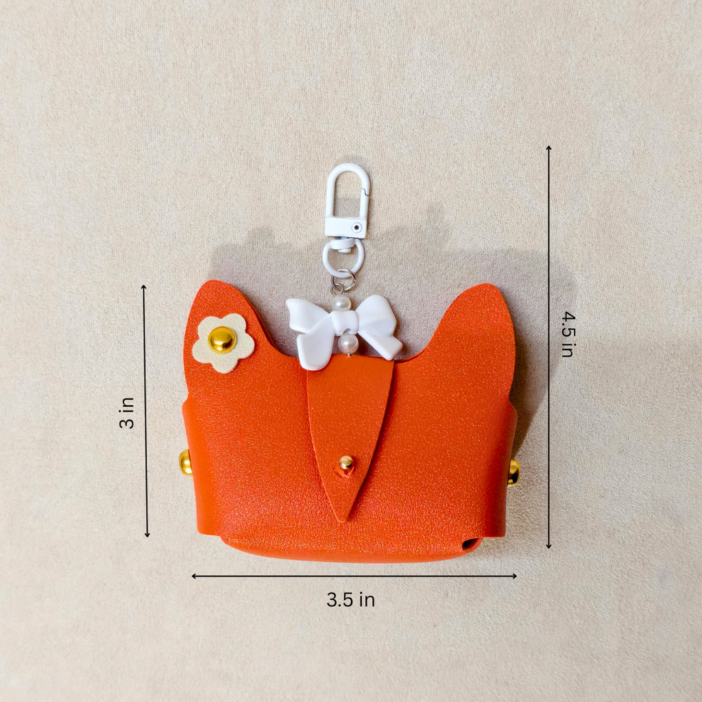 Orange cat-shaped airpods case with measurements on a beige background