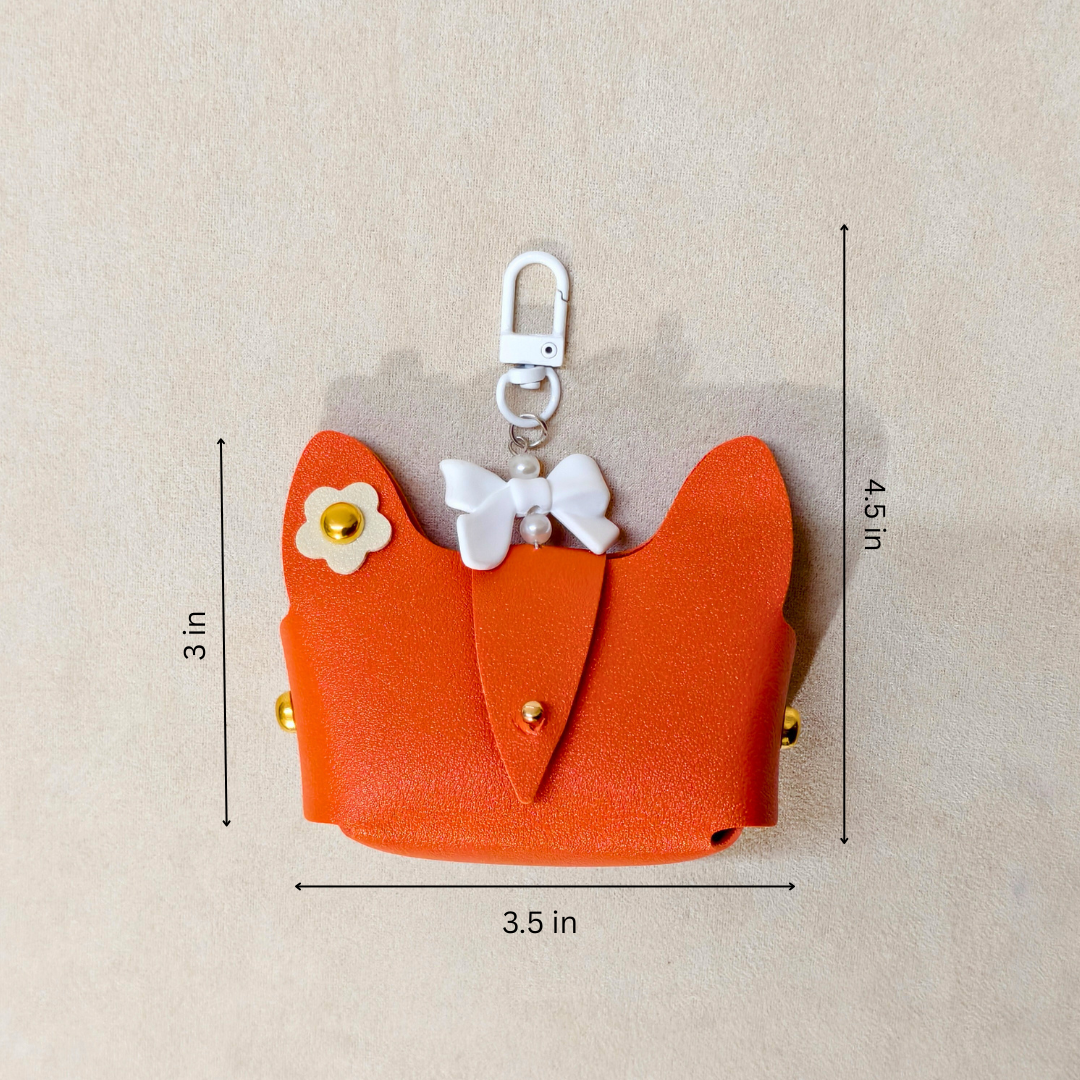 Orange cat-shaped airpods case with measurements on a beige background