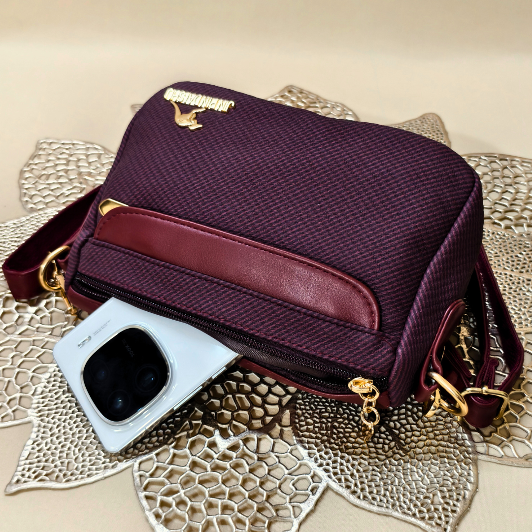 Purple handbag with gold accents on a decorative surface