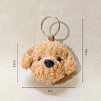 Teddy bear-shaped keychain with measurements on a beige background