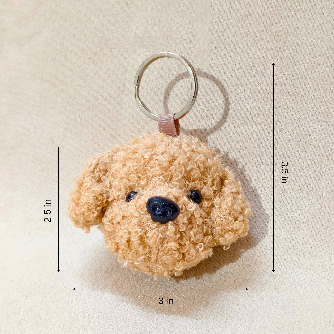 Teddy bear-shaped keychain with measurements on a beige background