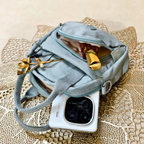 Blue handbag with gold accents on a textured surface