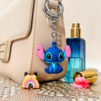 Blue cartoon character keychain with pink accents on a beige handbag with a blue bottle and pink item.