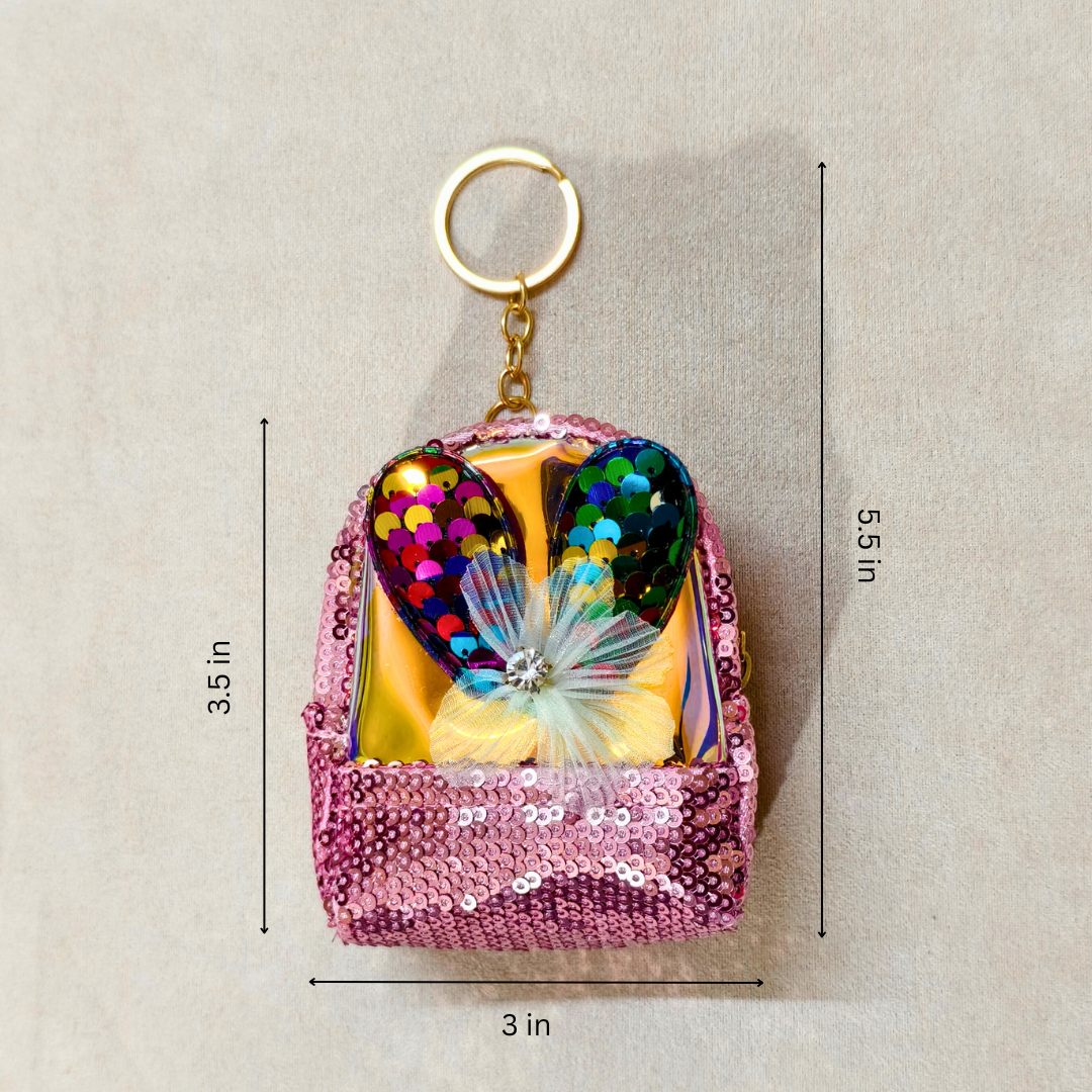 Colorful butterfly keychain in a pink sequin bag with measurements on a beige background