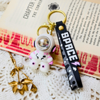 Small Astronaut Keyring With Props On Crochet Background.