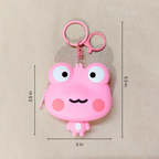 Pink cartoon frog-shaped keychain with measurements on a beige background