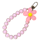 Pink beaded keychain with a flower charm on a white background