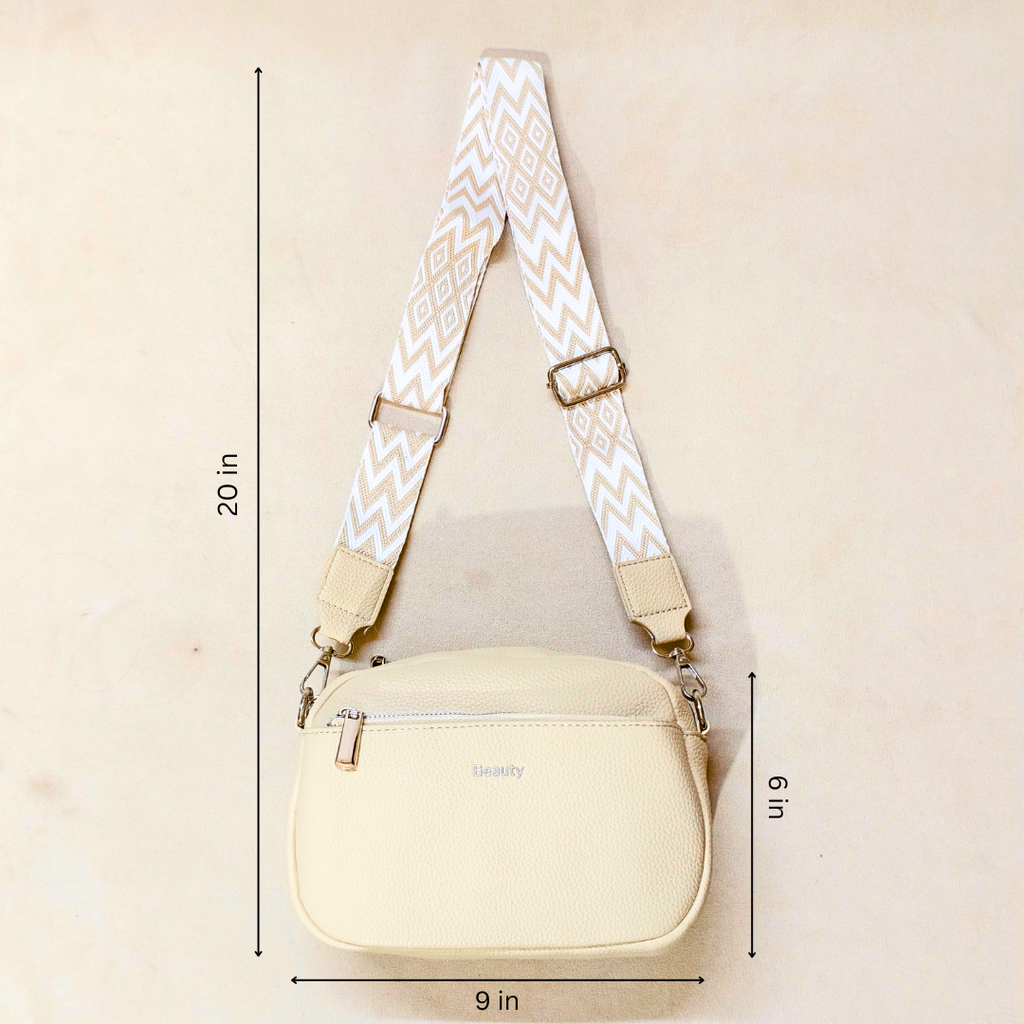 A cream-colored crossbody bag with a patterned strap, shown with dimension lines indicating measurements of 20 inches in height, 9 inches in width, and 6 inches in depth.