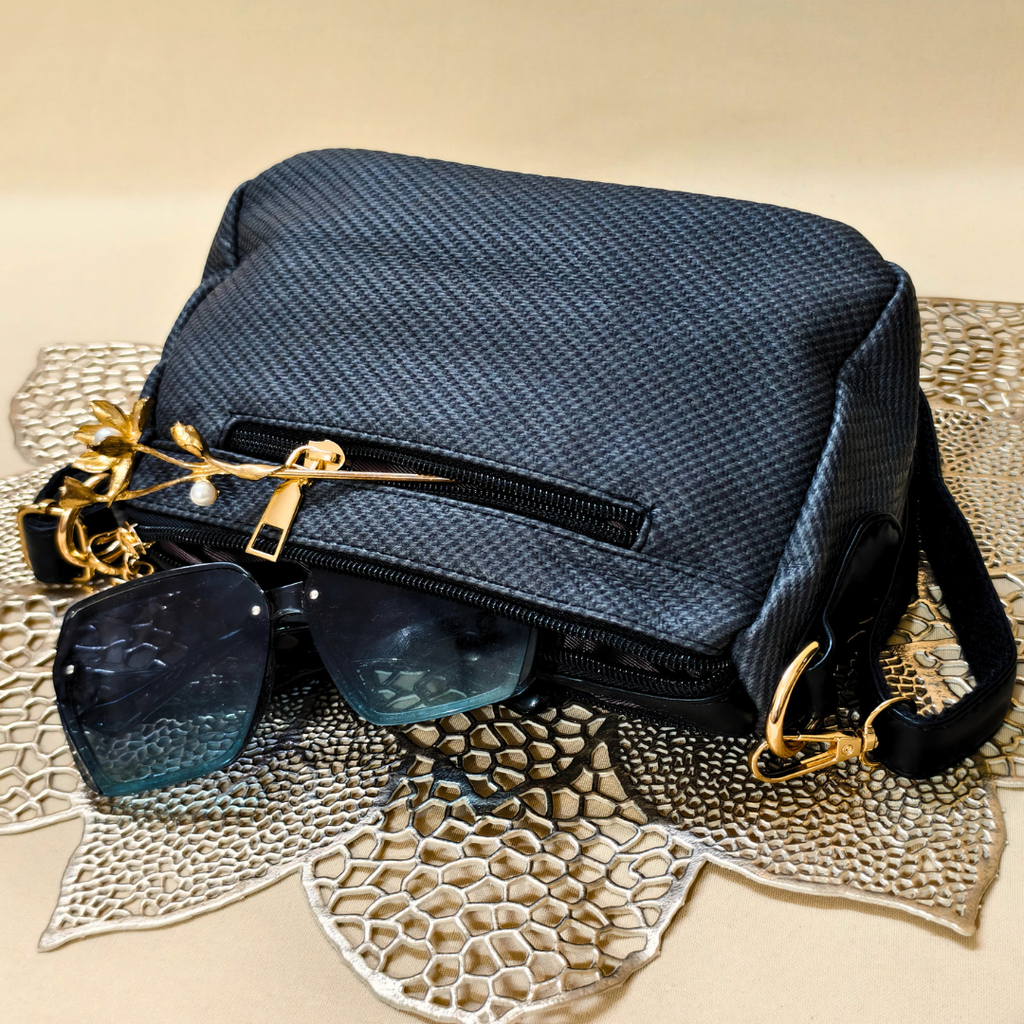 Blue textured handbag with sunglasses on a textured surface
