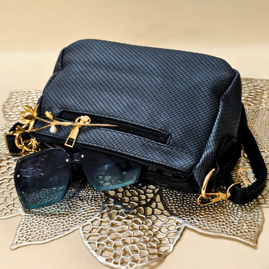 Blue textured handbag with sunglasses on a textured surface
