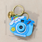 Blue cartoon camera keychain with measurements on a beige background
