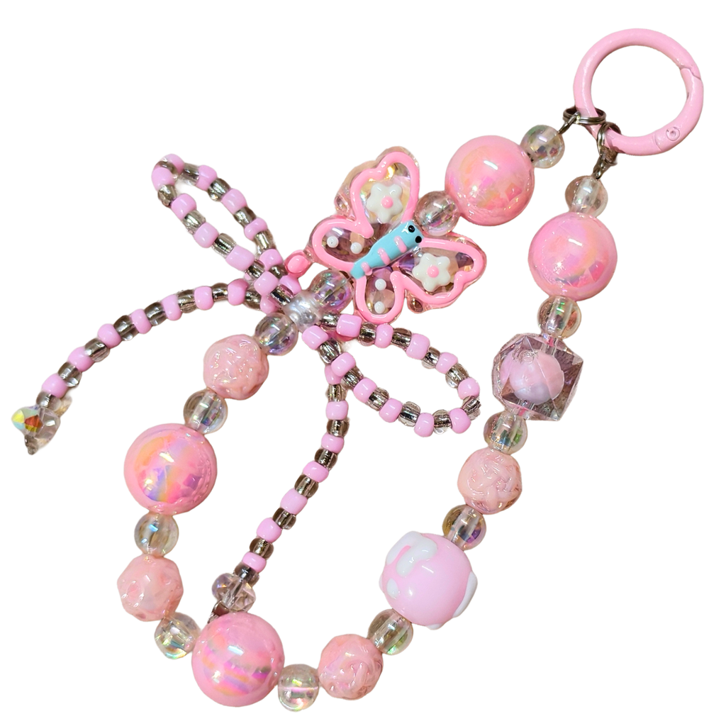 Pink butterfly charm with beads on a white background
