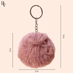 Pink fluffy keychain with measurements on a beige background