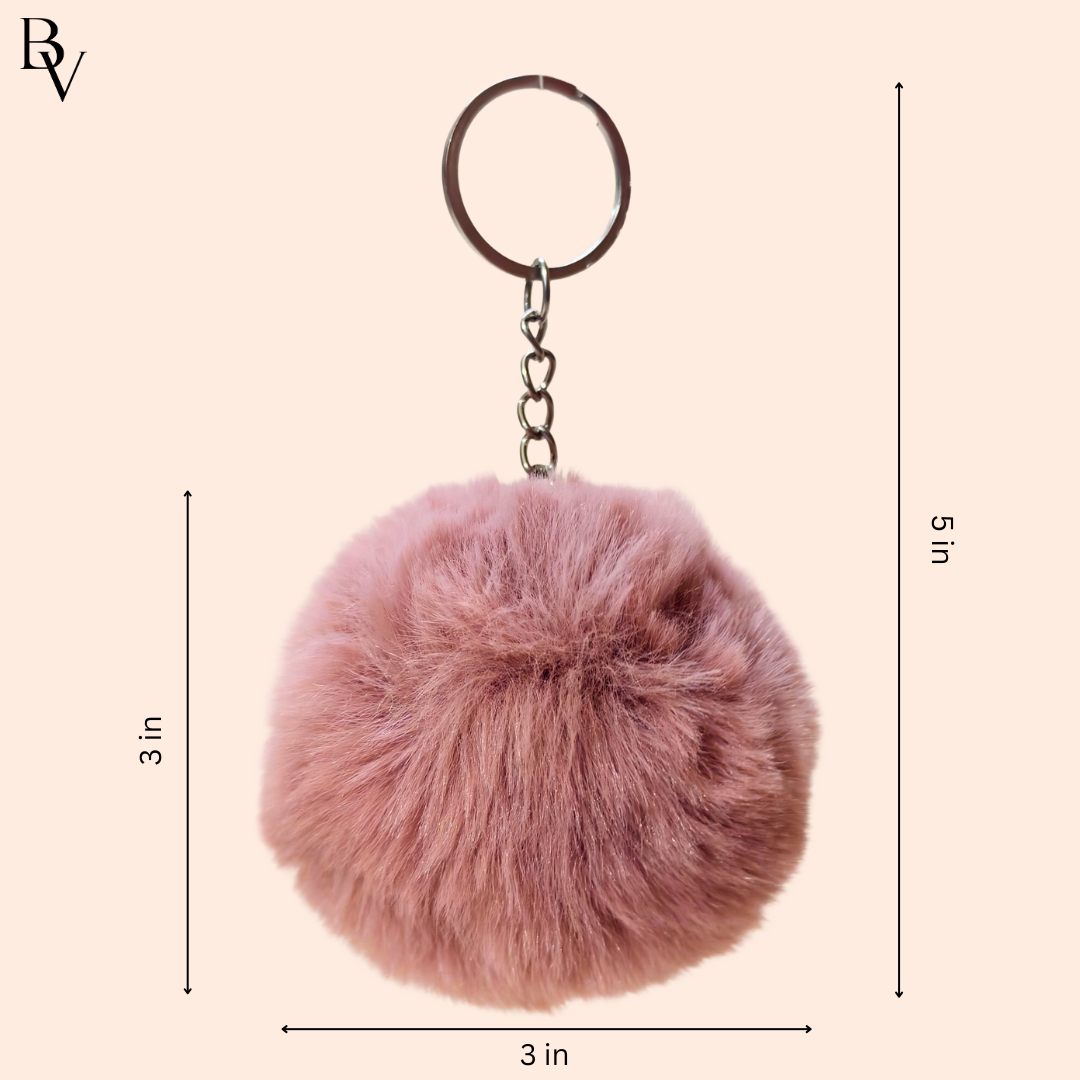 Pink fluffy keychain with measurements on a beige background