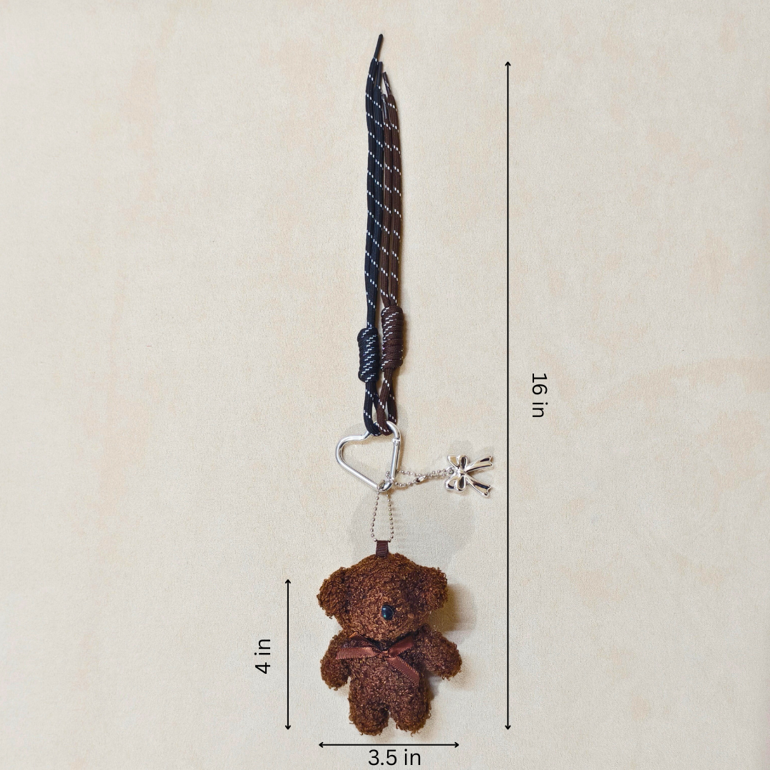 Brown teddy bear keychain with measurements on a beige background